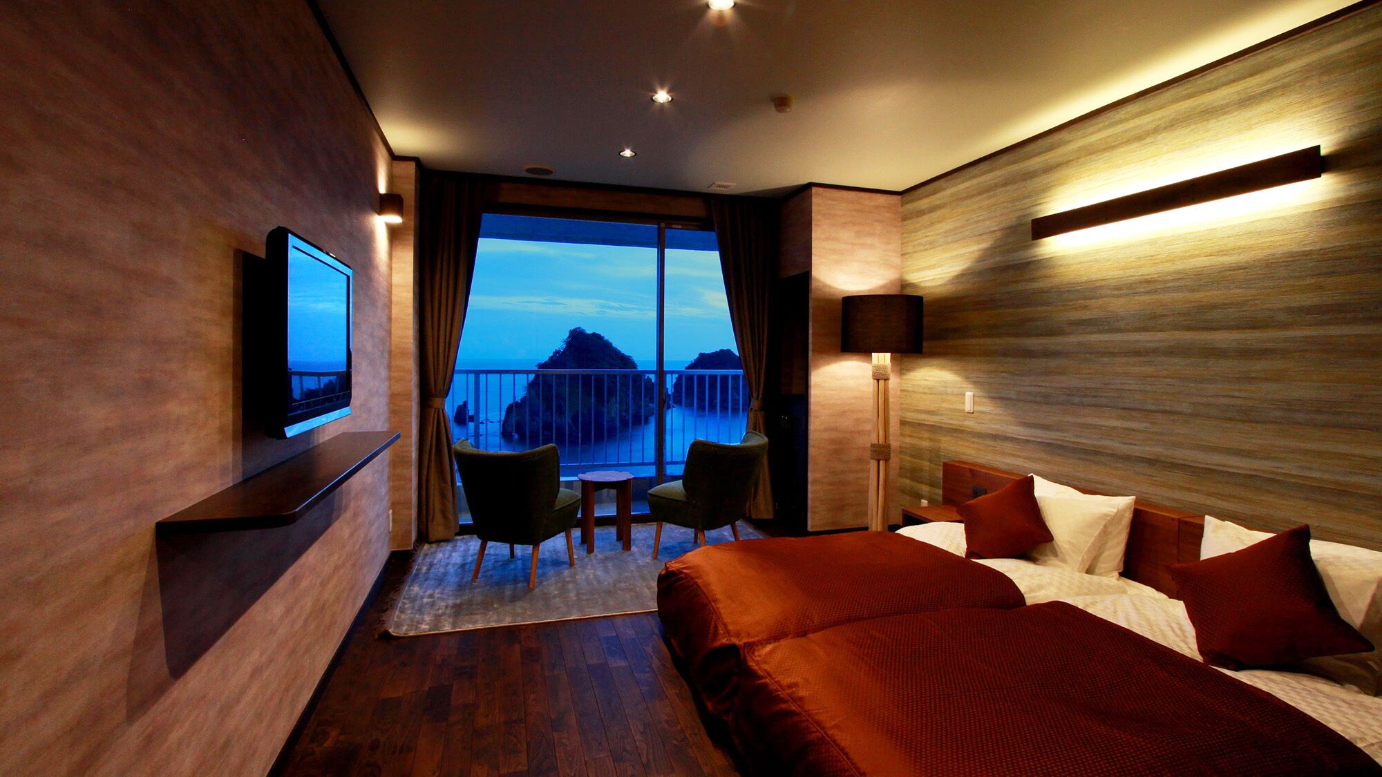 Hotelkamer met een bed, televisie, balkon en bureau.