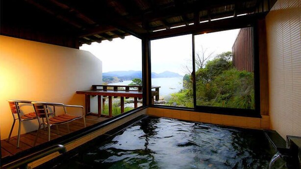 A hot tub with a view of a lake and mountains. - Dogashima Hotel Tenyu (Nishiizu)