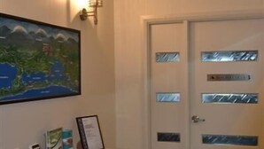 A reception area with a white counter displaying brochures and a framed map. - Bancroft Views Apartments (Metung)