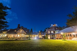 A traditional European-style building with a well-lit entrance and a grassy courtyard. - Luna Observatory Auberge Mori No Atelier (Minamiaso)