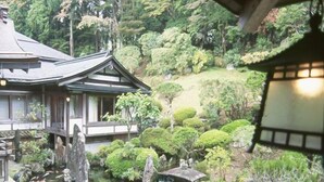 A traditional Japanese-style building with a koi pond and rock formations. - Ichijoin (Koya)