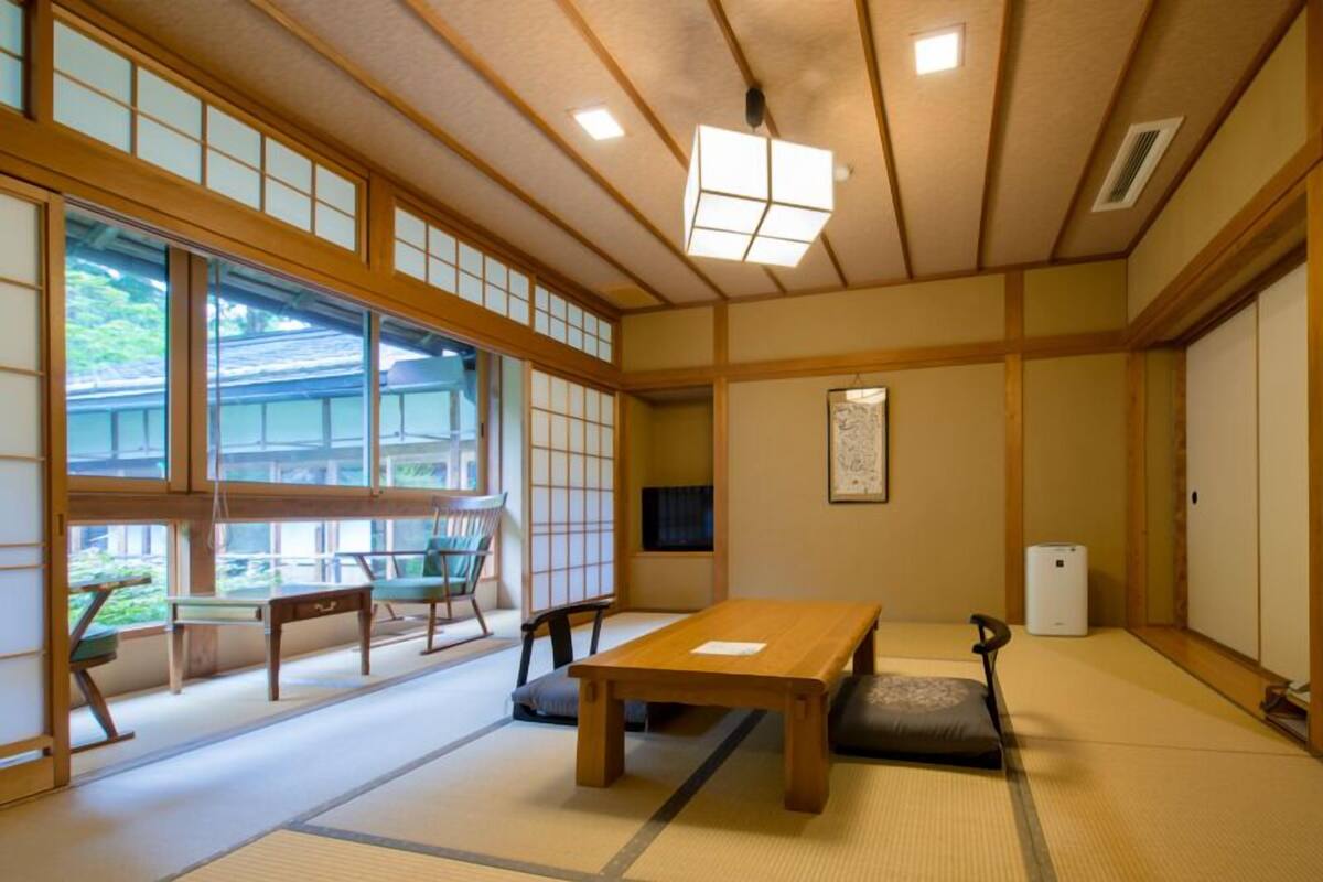 A traditional Japanese room with tatami flooring, a low wooden table, and sliding doors.