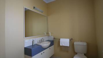 Ein Badezimmer mit Waschbecken, Spiegel und Toilette.