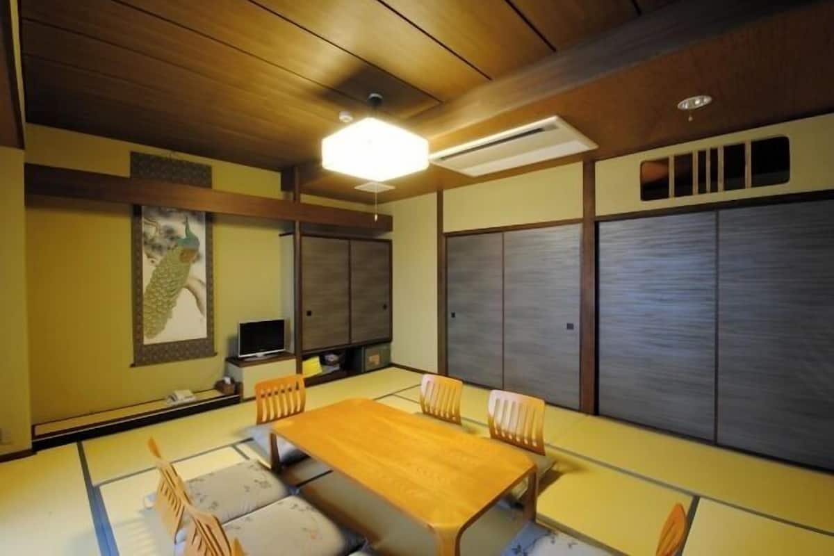A traditional Japanese room with tatami flooring, a wooden table, and sliding doors.
