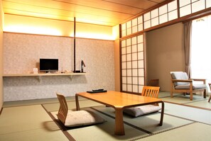 A traditional Japanese room with tatami flooring, a low table, chairs, a television, and sliding doors. - Miyahama Onsen Miyahama Grand Hotel (Hatsukaichi)