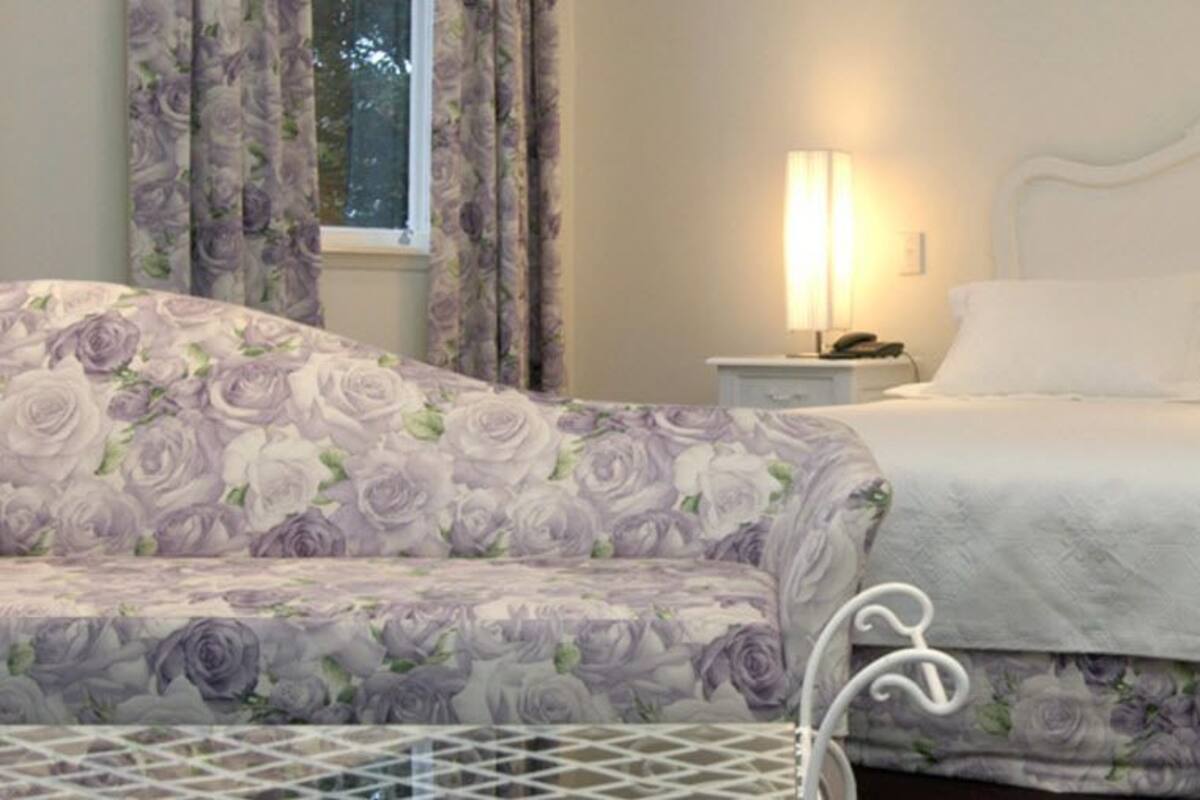 A bedroom with a bed, two bedside tables, and a nightstand.
