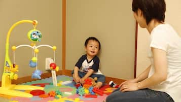 A child playing with toys on a colorful play mat.