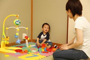 Un niño jugando con juguetes en un tapete de juegos colorido.