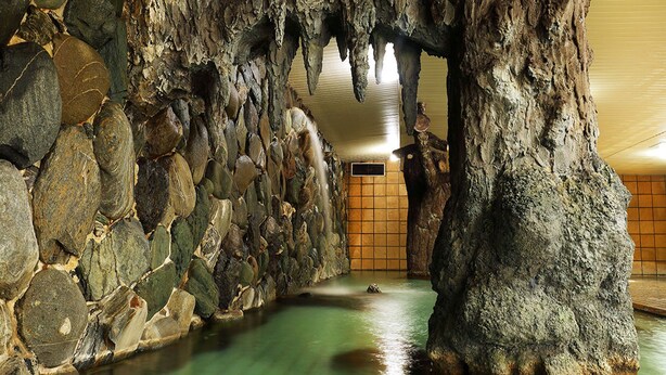 A cave-like interior with natural rock formations and a water feature. - Ryokan Yubara International Tourist HOT (MANIWA SHI)