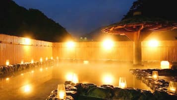 A hot spring bath area with stone seating and candles.