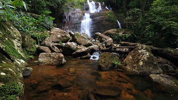 A natural waterfall surrounded by rocks and greenery.