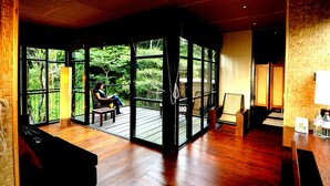 Una habitación con ventanas amplias, suelo de madera y vistas al exterior.