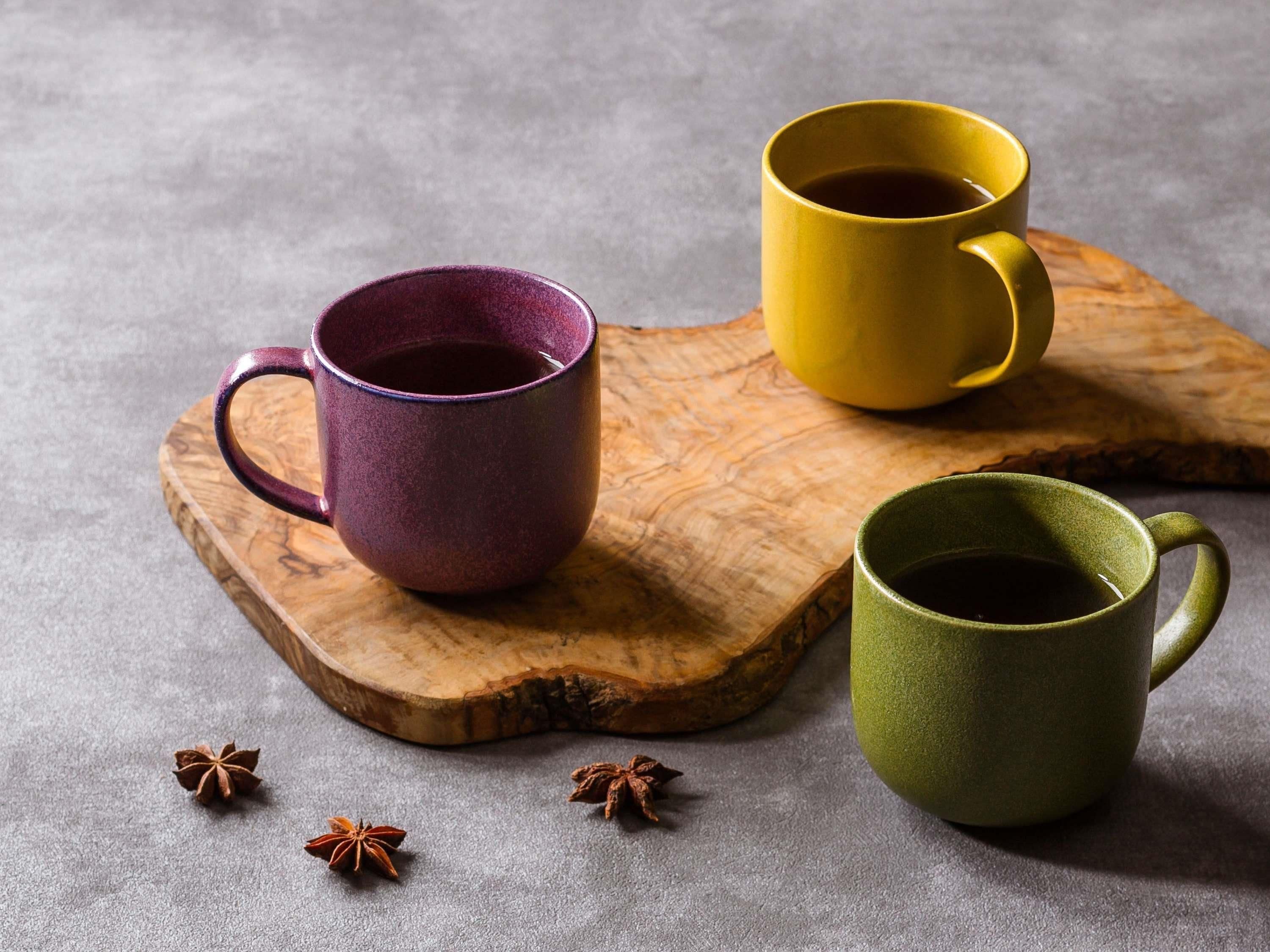 Tres tazas sobre una tabla de madera.