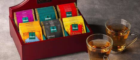 A tea display with various tea bags and two glasses of tea.