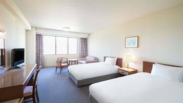 A hotel room with two beds, a desk with a television, a chair, a nightstand with a lamp, and a window with curtains.