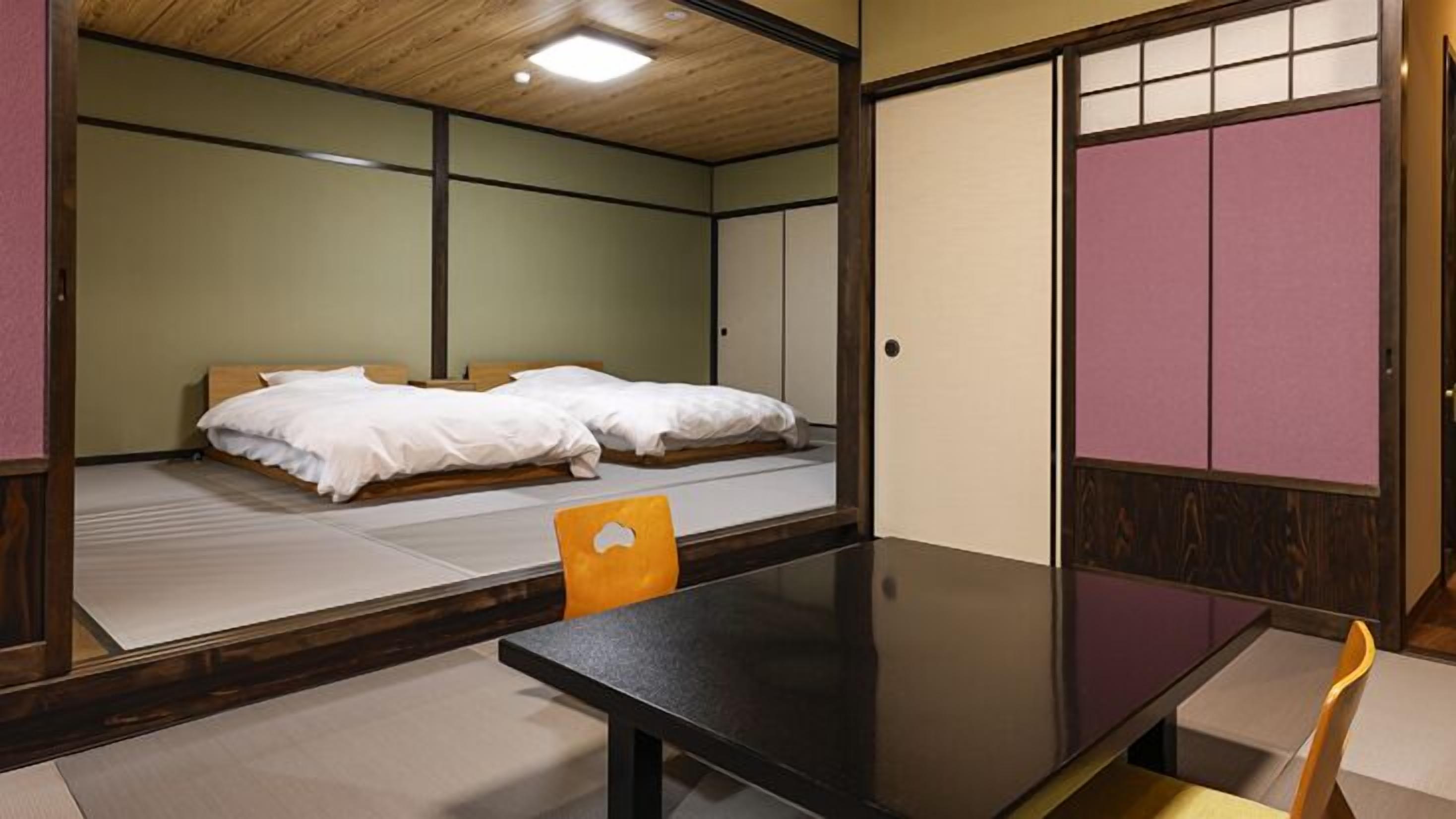 A traditional Japanese-style room with tatami flooring, a low wooden table, and a futon bed.