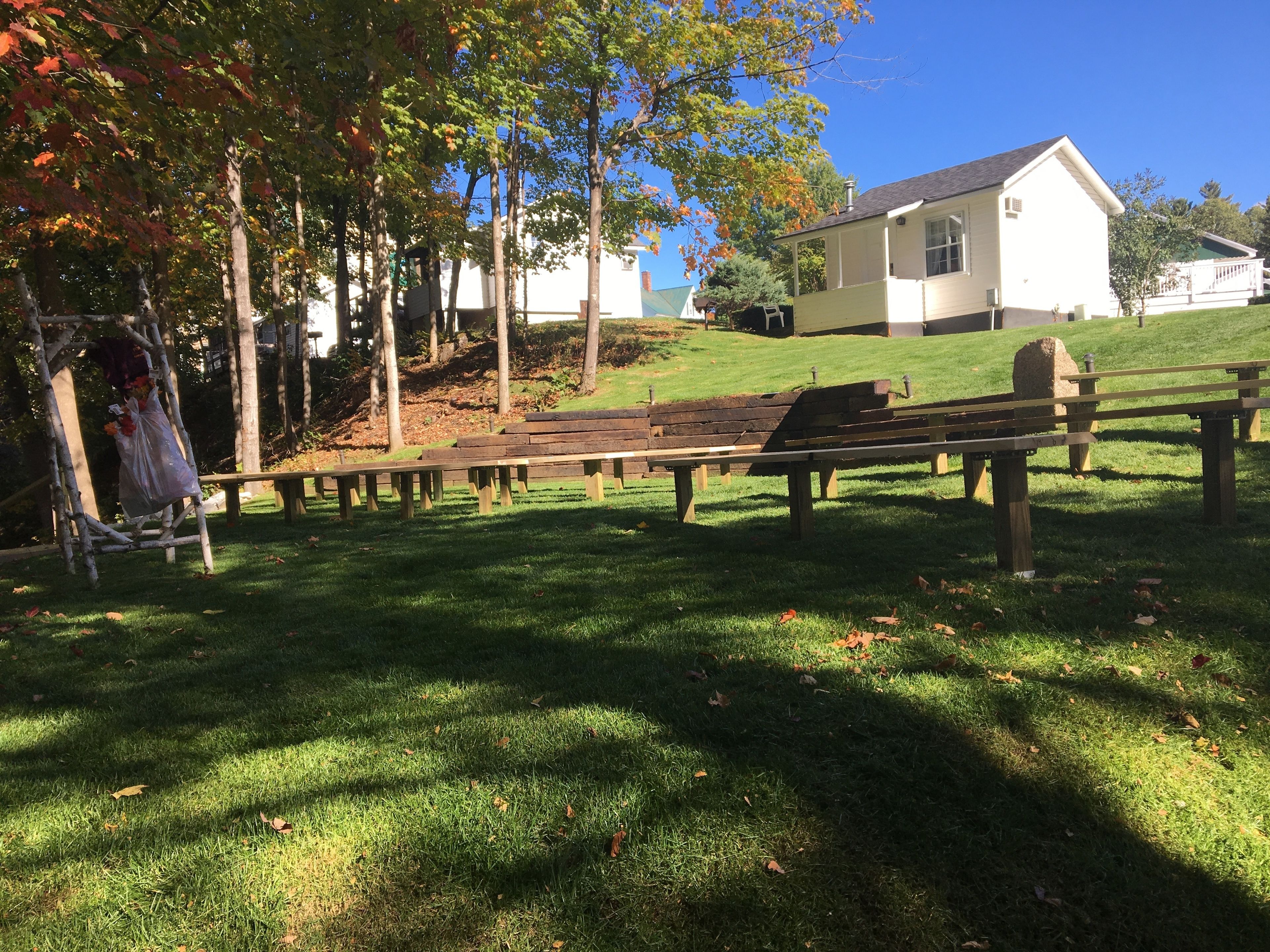 Un espace herbeux avec un banc en bois et une balançoire.