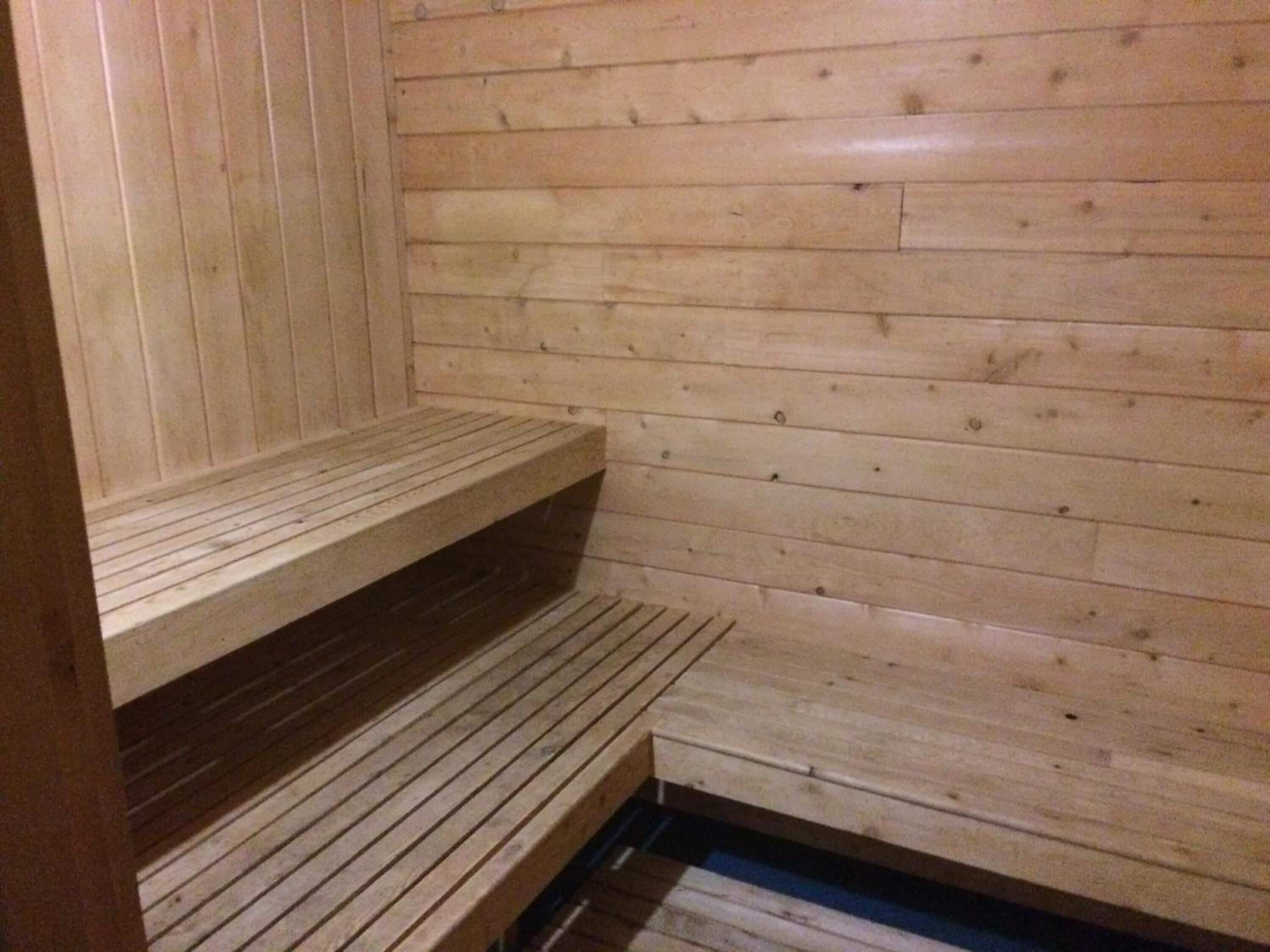 Una sauna de madera con bancos y escalones.