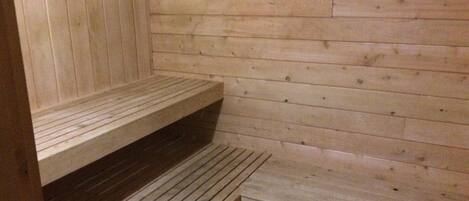 Una sauna de madera con bancos y escalones.