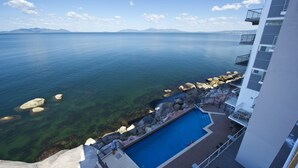 A pool area with clear water, rocks, and a view of the sea and mountains. - 1 Bright Point Apartment 5404 (Nelly Bay)