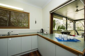 A kitchen with a sink, a kettle, and a blue tray with cups and a teapot. - Marramaninjie (Arcadia)