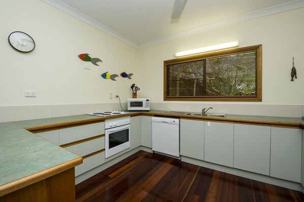 A kitchen with white cabinets, a microwave, a stove, and a dishwasher.