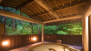 A wooden hot tub with a wooden deck and railings, surrounded by a wooden fence and trees. - Hanamaki Onsen Kashoen (Hanamaki)