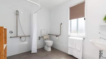 A modern bathroom with a shower, toilet, and sink.