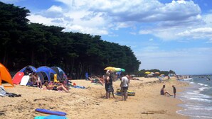 A beach with tents, umbrellas, and people. - Bellarine Bayside Holiday Parks (Portarlington)