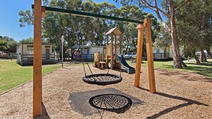 A playground with a swing set, tire swings, and a slide. - Bellarine Bayside Holiday Parks (Portarlington)