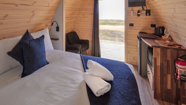 A cozy wooden room with a bed, a desk, a chair, and a television. - Bellarine Bayside Holiday Parks (Portarlington)