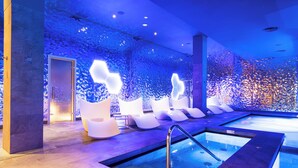 A modern indoor pool area with a glass wall, white lounge chairs, and a central pool. - HOVIMA Cool Costa Adeje (Adeje)