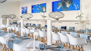 A modern dining area with white chairs, blue tablecloths, and overhead wire lamps. - HOVIMA Cool Costa Adeje (Adeje)
