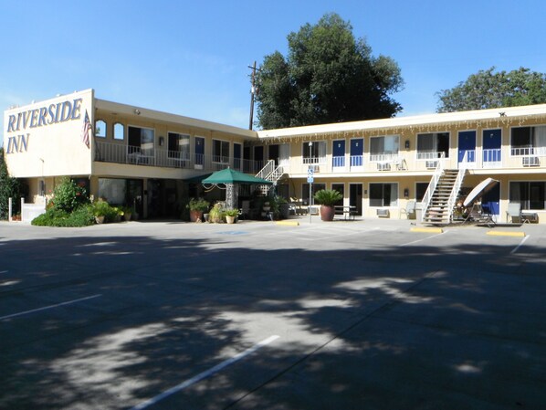 A Riverside Inn with a two-story structure, outdoor seating area, and a parking lot. - Colusa Riverside Inn (Colusa)