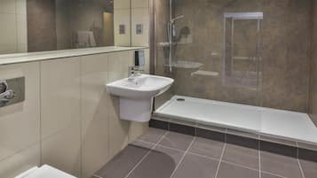 A modern bathroom with a sink, shower, and bathtub.