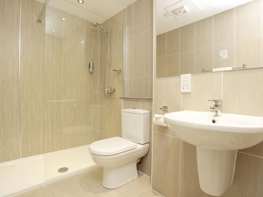 A modern bathroom with a shower, toilet, and sink.