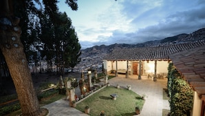 A courtyard with a tiled roof, stone pathway, and potted plants. - Palacio Manco Capac by Ananay Hotels (Cusco)