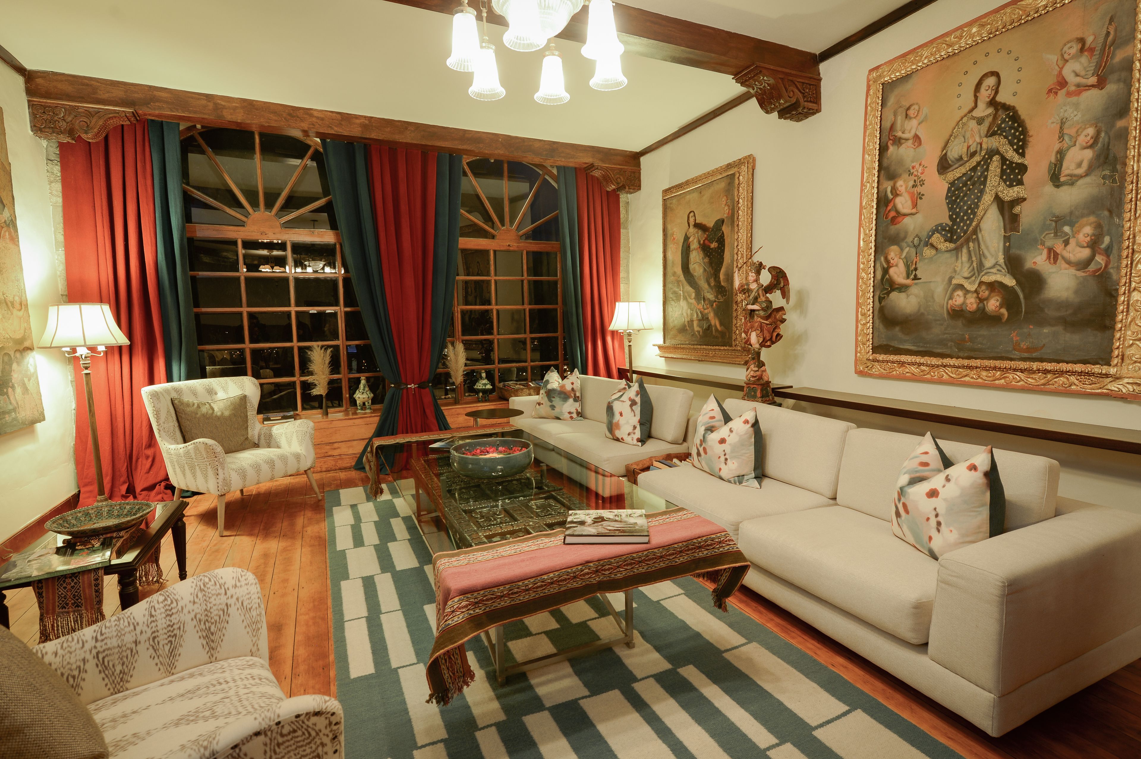 A traditional living room with a sofa, armchairs, a coffee table, and a fireplace.