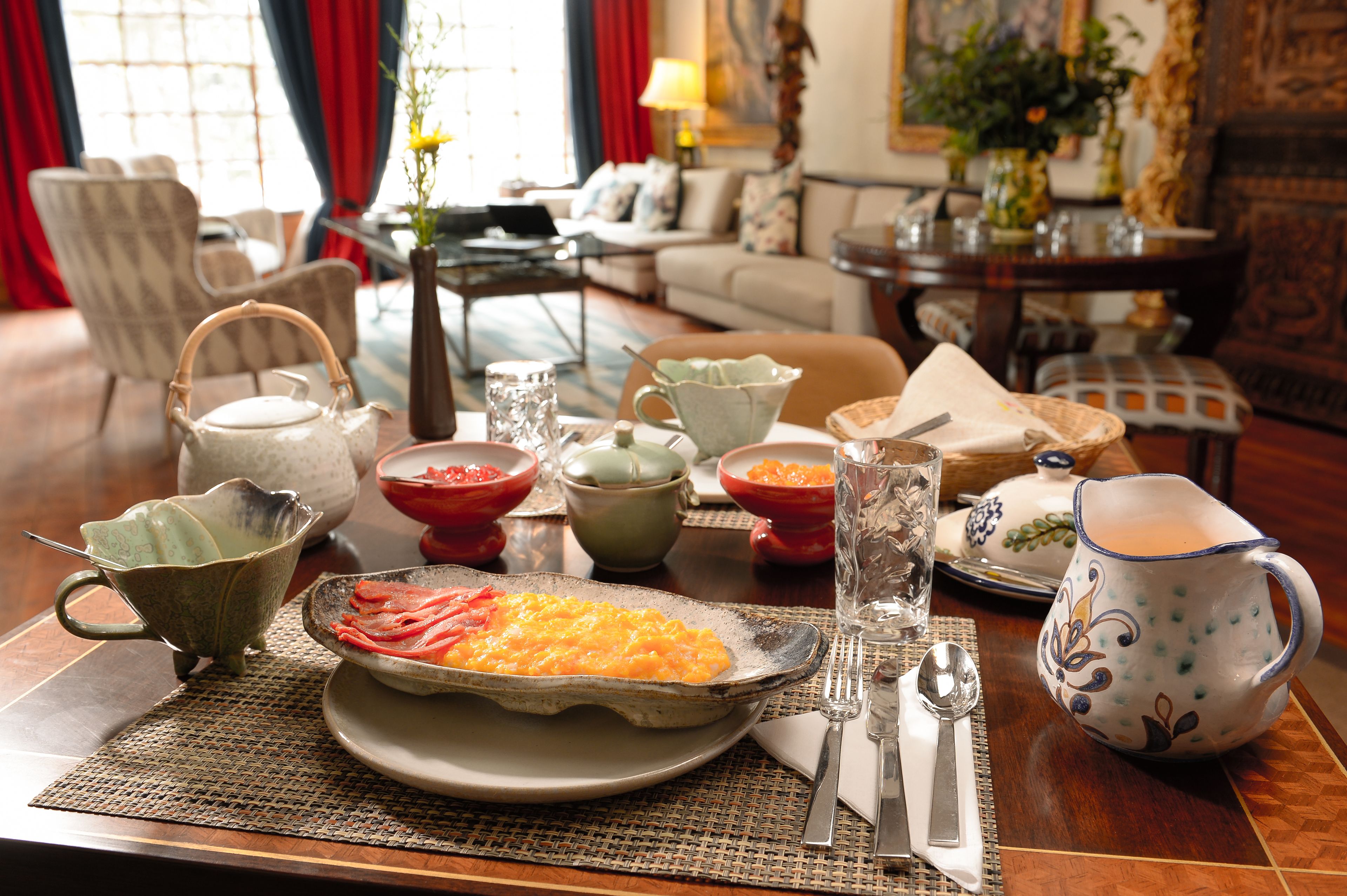 A dining table set with various dishes and tableware in a well-furnished room.