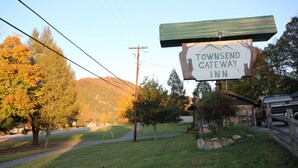 A sign for Townsend Gateway Inn with a view of a grassy area and trees. - Townsend Gateway Inn (Townsend)