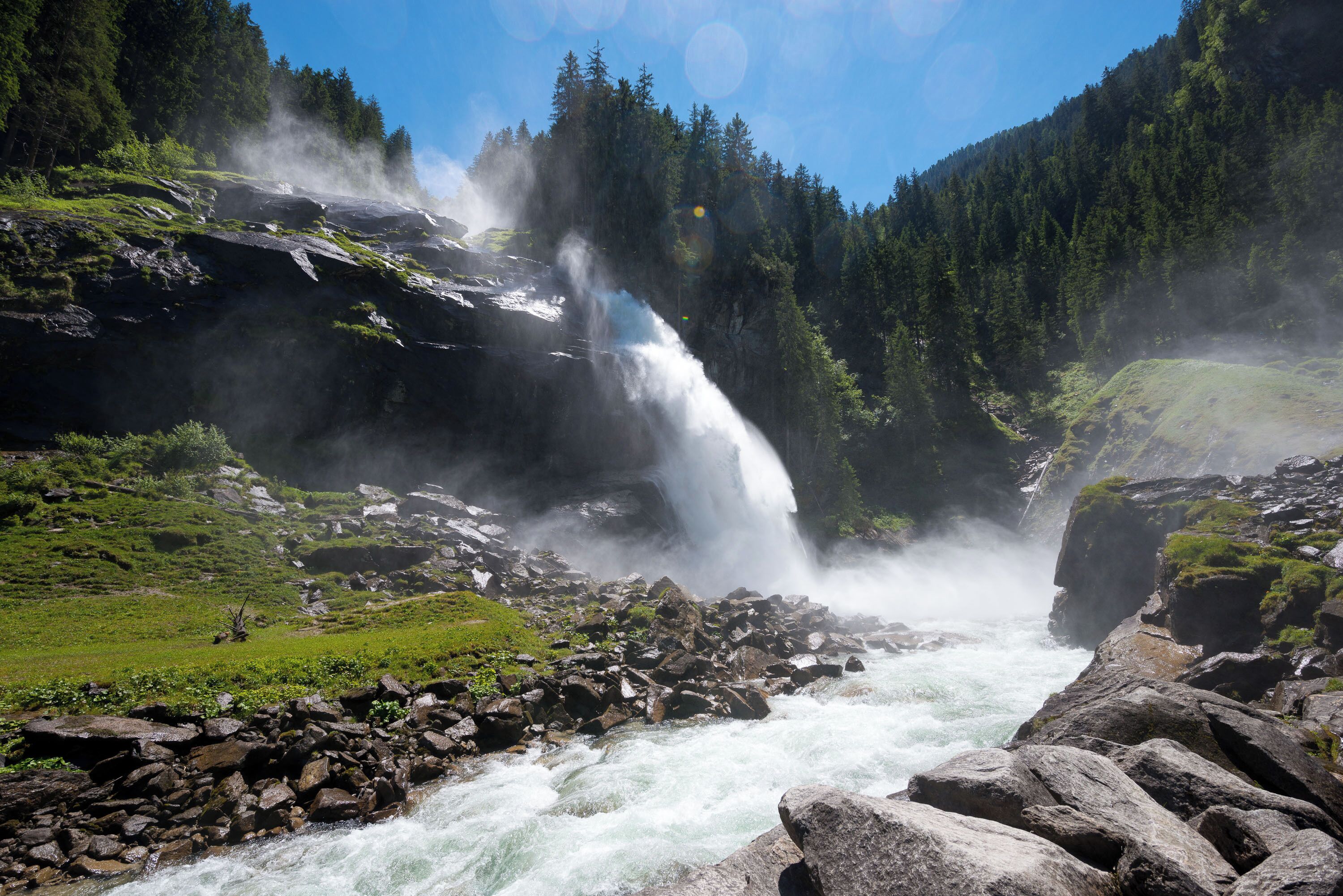 A waterfall cascading over rocks in a forested area.