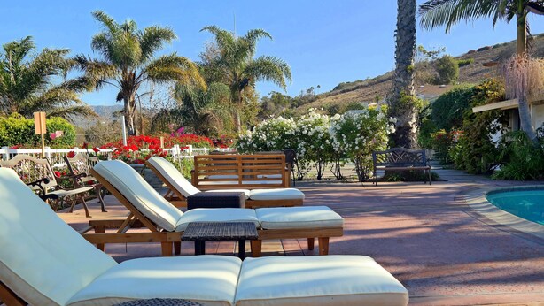 A poolside area with sun loungers and a small round table.