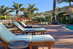 A poolside area with sun loungers and a small round table.