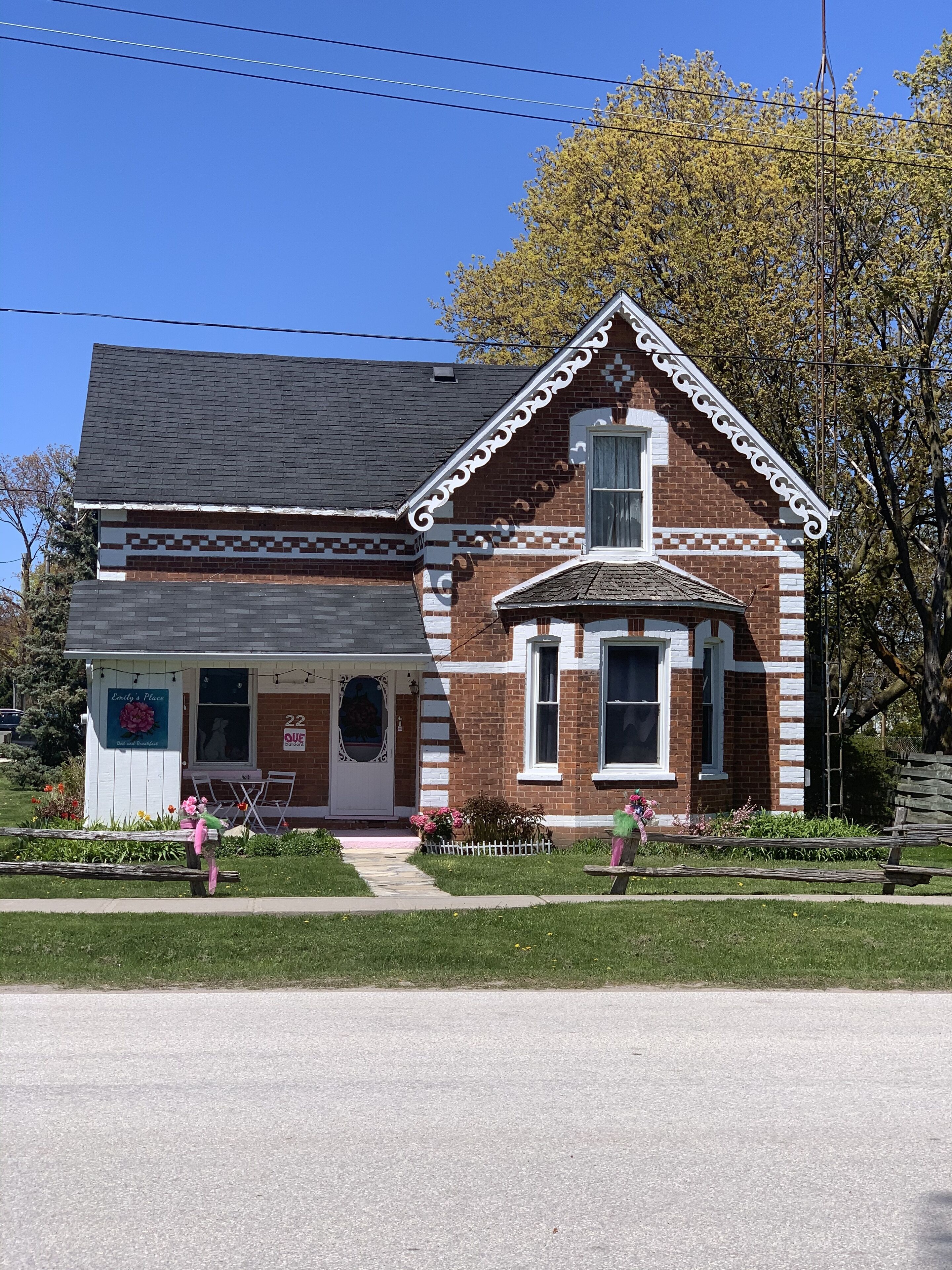 A two-story brick building with a white trim and a small porch.