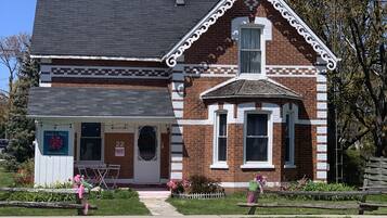 A two-story brick building with a white trim and a small porch.