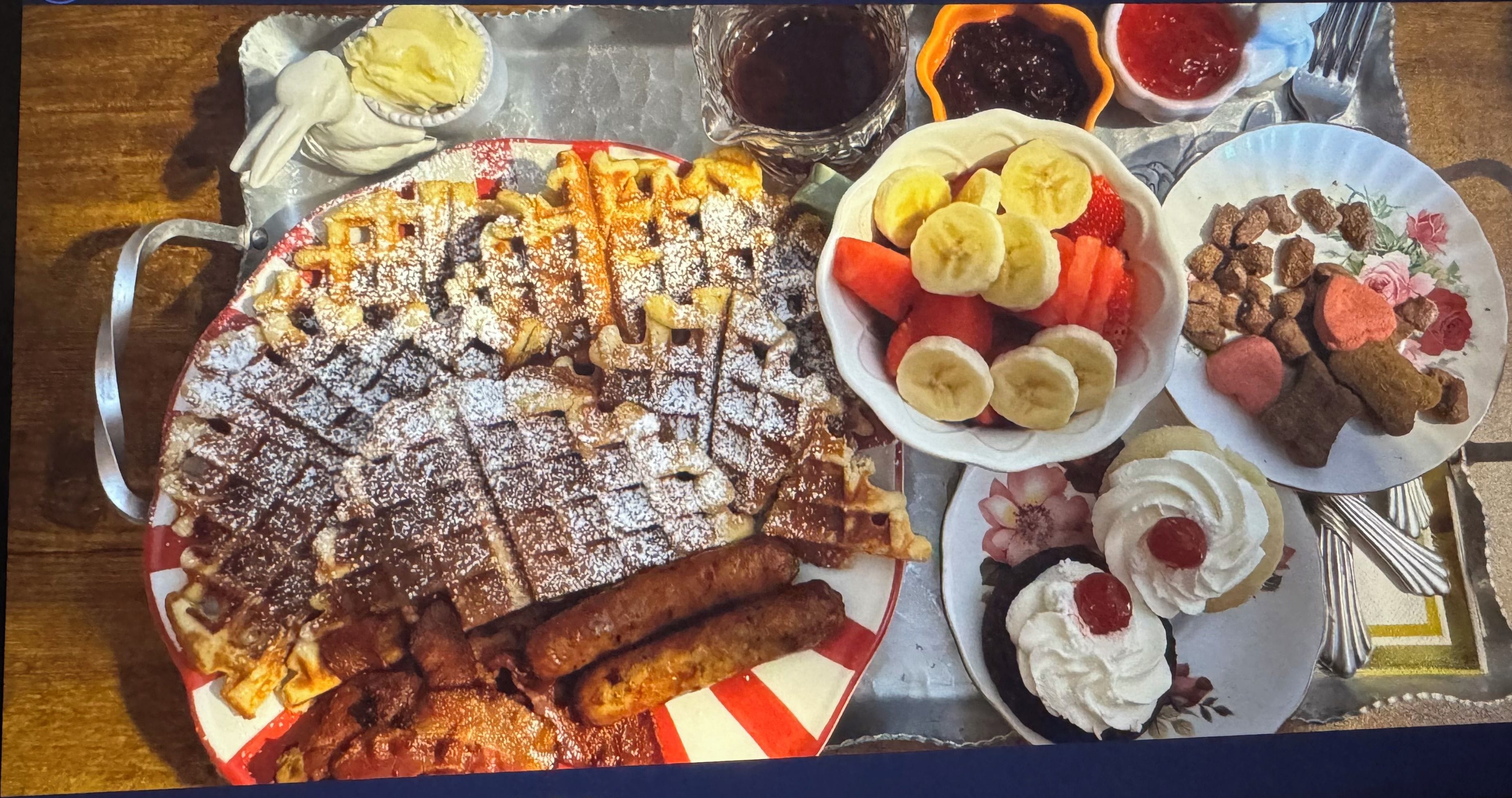Bandeja de desayuno con waffles sin gluten, fruta y pasteles.