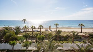 A beach view with palm trees and a white fence. - Grand Palladium White Island Resort & Spa - All Inclusive (Sant Josep de sa Talaia)