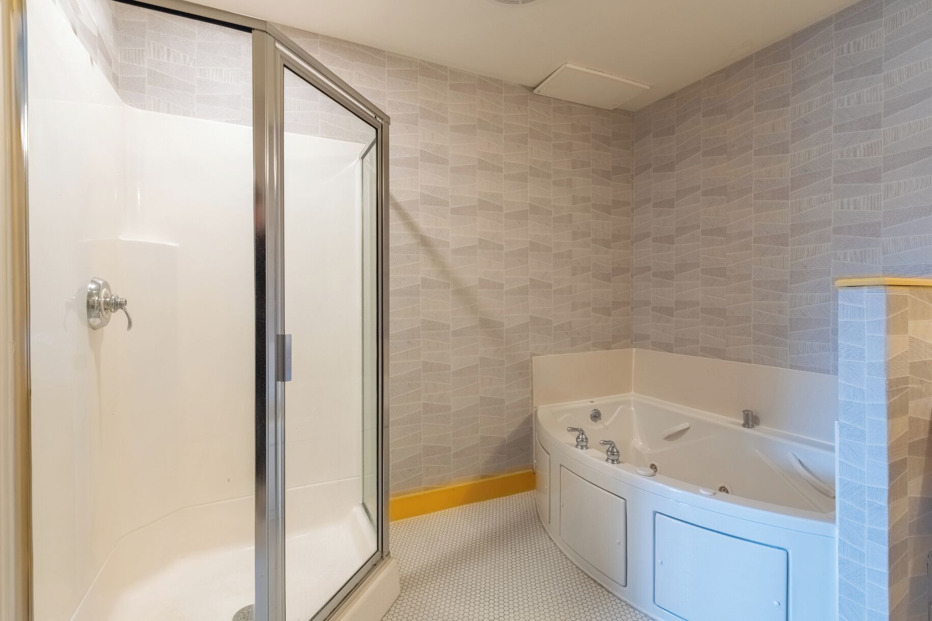 Une salle de bain avec une douche à parois de verre, une baignoire et des toilettes.