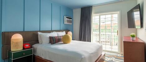 Una habitación de hotel con cama, mesita de noche, televisor y ventana con vista.