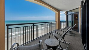 A balcony with a view of the beach and ocean. There are two wicker chairs and a small round table. - Island Vista Resort (Myrtle Beach)